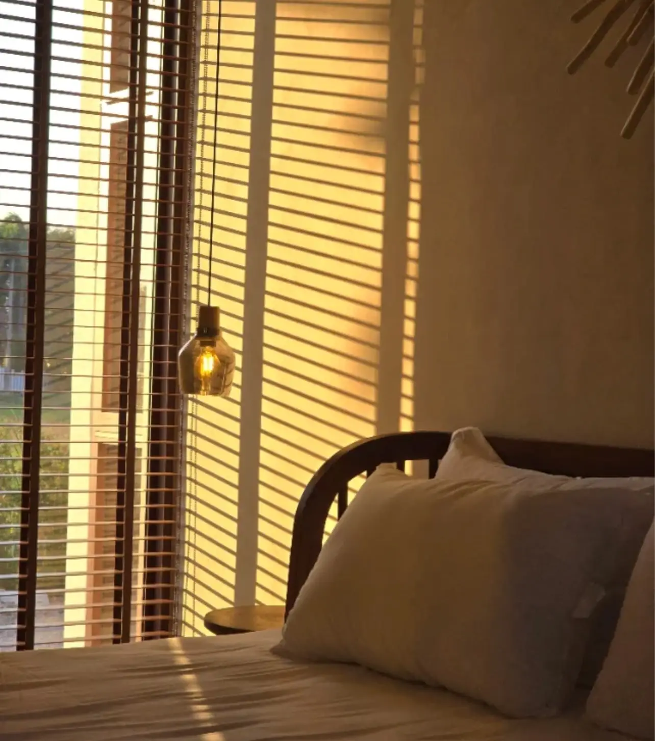 Bed in sunlight through the blinds