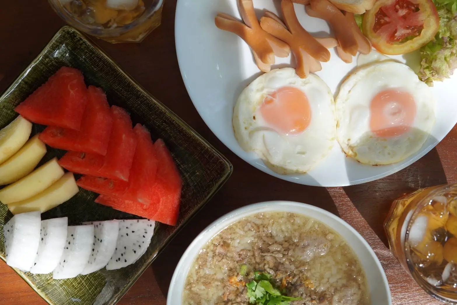 Breakfast of fruit, fried eggs and rice porridge