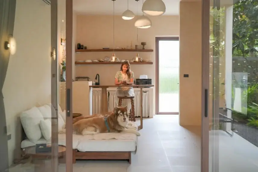 A guest in the villa kitchen with a dog resting nearby